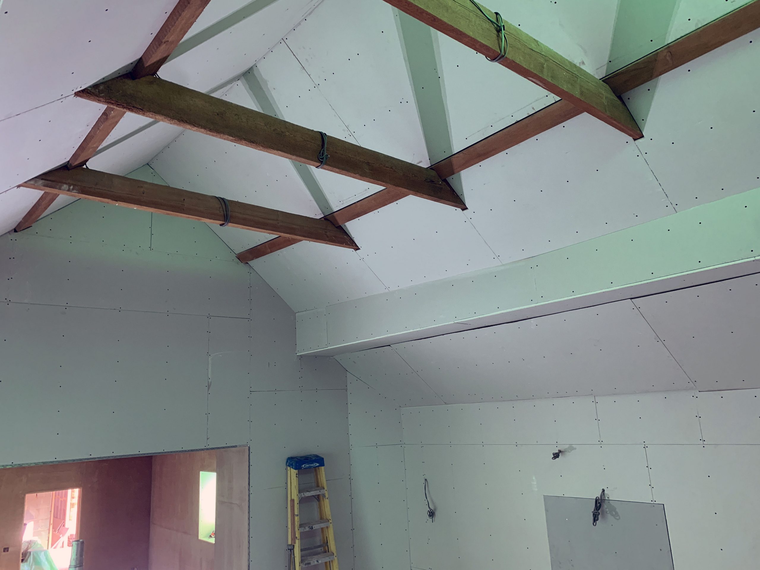 Plaster boarded pitched ceiling with wooden beams